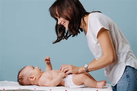 Femeie schimbând scutecul bebelușului pe o aleza