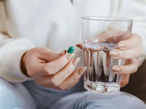 Femeie însărcinată bând apă dintr-un pahar