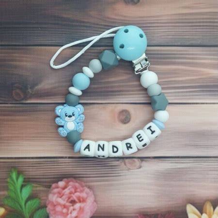 Imaginea unui lănțișor personalizat pentru suzetă, cu nume brodate și cu bile de silicon