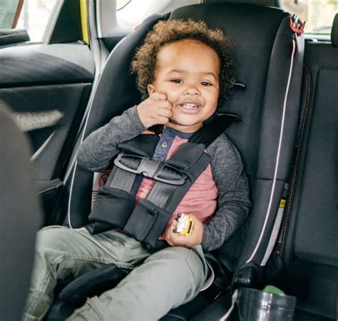 Copil într-un scaun auto special pe bancheta din spate