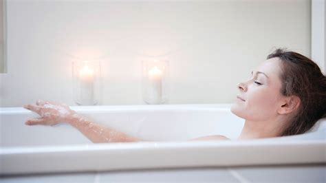 Femeie însărcinată relaxându-se într-o baie caldă