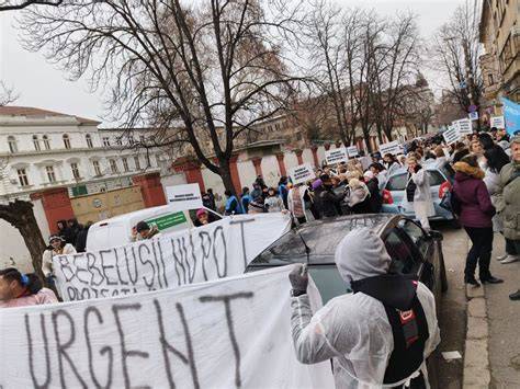 Imaginea unei clădiri spitalicești cu semne de protest în fața maternității