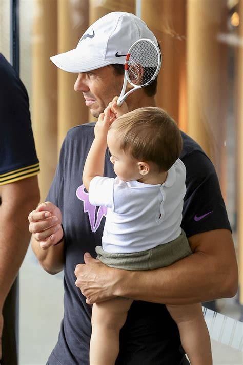 Imagine cu Rafael Nadal pe terenul de tenis și fiul său de trei ani pe margine, la un meci