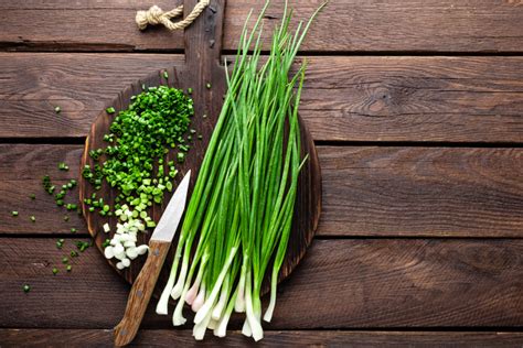 Ceapă verde și ceapă albă pe un fundal de lemn