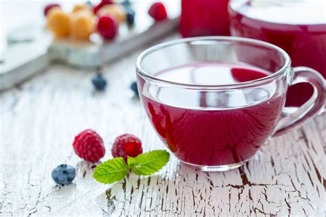 Femeie însărcinată bând ceai de zmeură