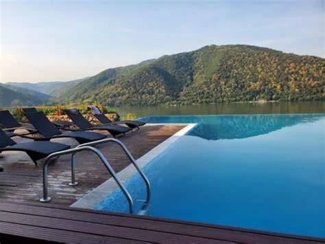 Fotografie cu piscina în aer liber a Pensiunii Danubia și priveliște asupra Dunării