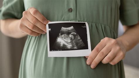 Femeie însărcinată masând delicat burtica