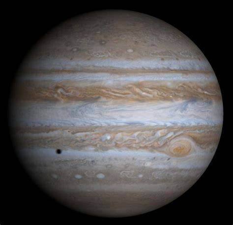 Imagine a planetei Jupiter obţinută de sonda spaţială Cassini. Punctul negru este umbra satelitului Europa. Credit: Wikimedia Commons