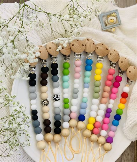 Infografic comparativ al materialelor pentru lănțișoare de suzetă (silicon, lemn, textil)