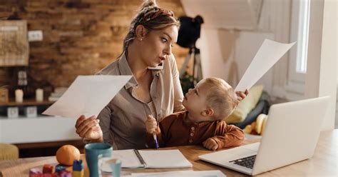 Femeie jonglând între muncă și copil