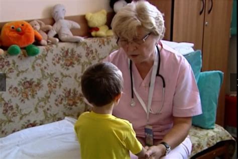 Medic pediatru examinând un copil zâmbitor