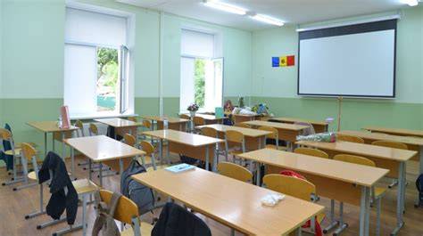 Imaginea unei clase de informatică cu copii activi în timpul pauzei