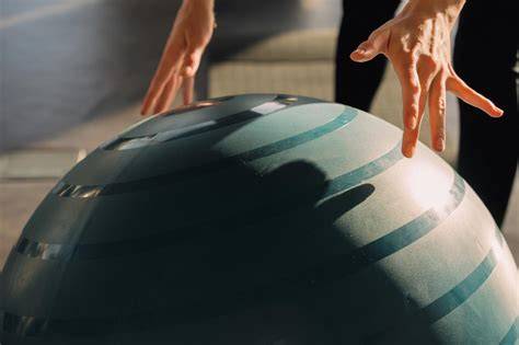 Gravidă făcând exerciții lângă o minge de pilates
