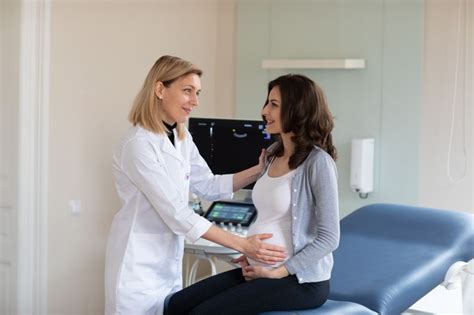 Femeie însărcinată discutând cu medicul