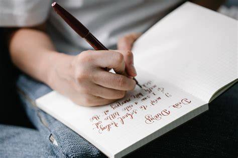 Imagine cu o mamă care scrie o scrisoare în jurnal în timpul sarcinii