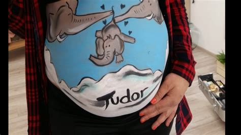 Artist pictând pe burtica unei gravide