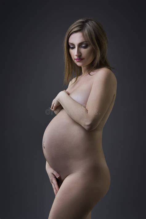 Imagine de studio cu femeie însărcinată în luna a cincea, lumina difuză și fundal neutru