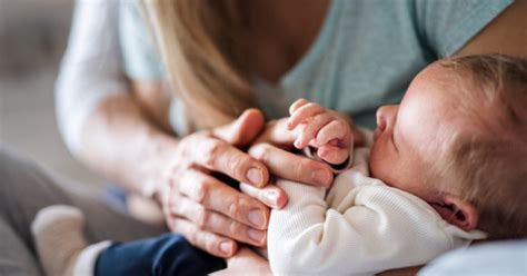 părinte care ține bebelușul în brațe după vaccinare