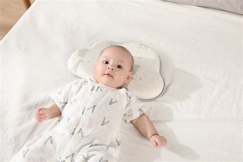 Bebelus dormind pe spate cu o perna speciala pentru cap