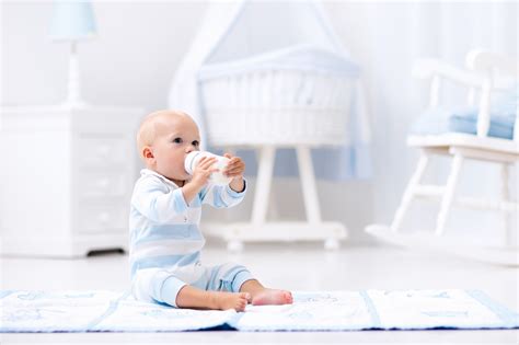 bebeluș care bea lapte din biberon