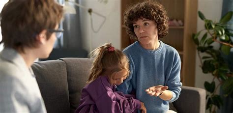 Pediatru discutând cu un copil și părinții săi