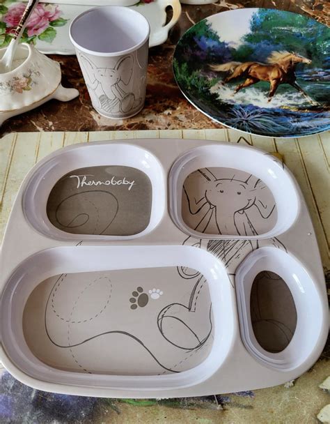 Fotografie cu o masă veselă, aranjată pentru un copil mic, cu tacâmuri adaptate.