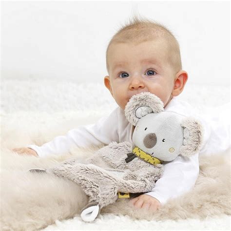 Un bebelus care imbratiseaza o jucarie doudou