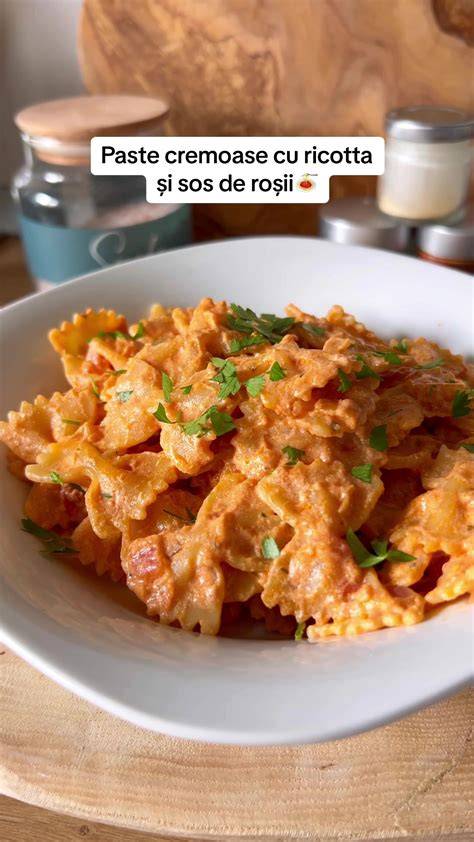 Imaginea unei mese cu paste cremoase din mascarpone, dovlecei și roșii coapte