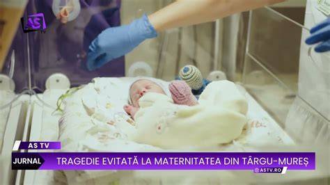 Imaginea unei mame sprijinindu-și copilul după nașere, în Maternitatea din Târgu Mureș, cu atmosfera Ora Magică
