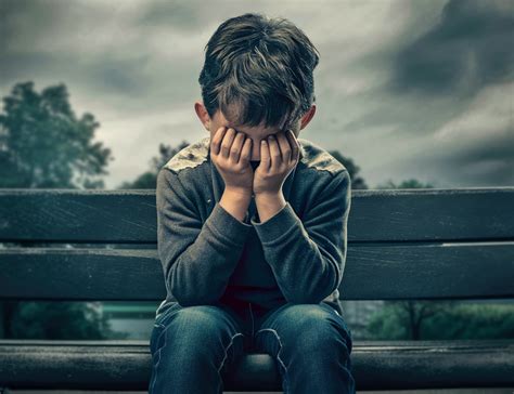 Copil trist ținându-se de burtă