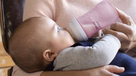 Ilustrație a bebelușului care ține biberonul Avent Natural